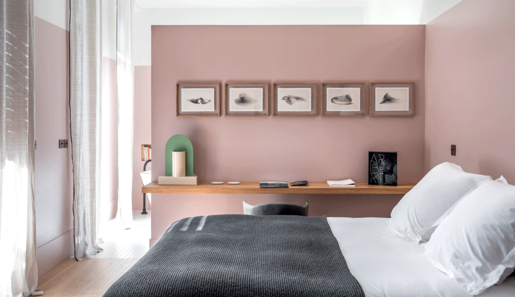 chambre-avec-lit-table-de-chevet-et-peinture-murale-rose