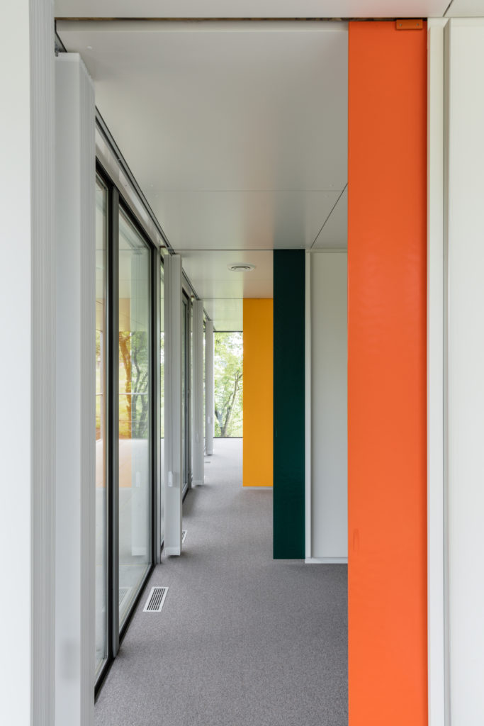 La résidence Paul Schärer intérieur coloré de jaune orange et vert avec baies vitrées